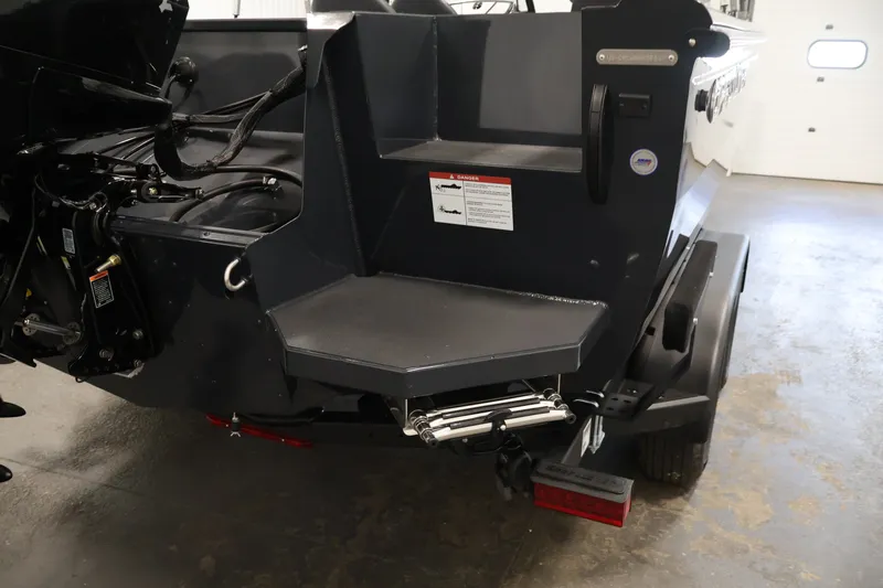 Slide: The Image of 2026 Crestliner 2050 Authority boat stern with motor and trailer in a garage setting. - 46