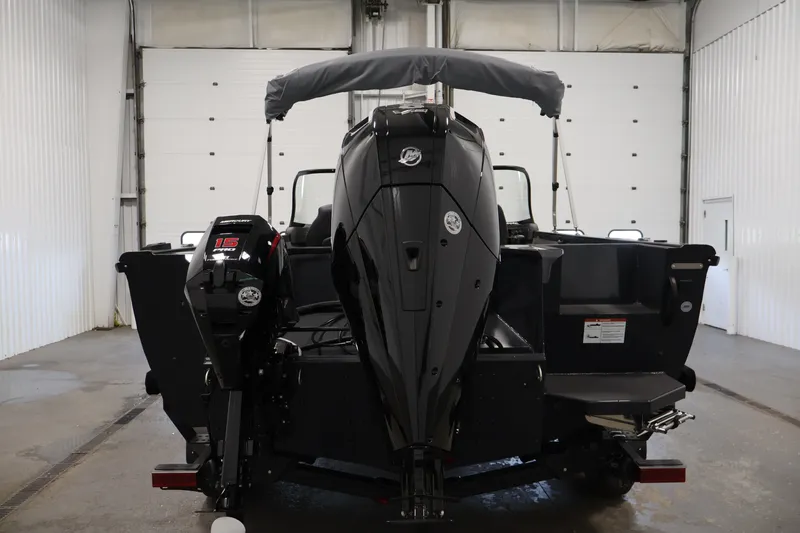Slide: The Image of 2026 Crestliner 2050 Authority boat in a garage, rear view with dual outboard motors. - 16