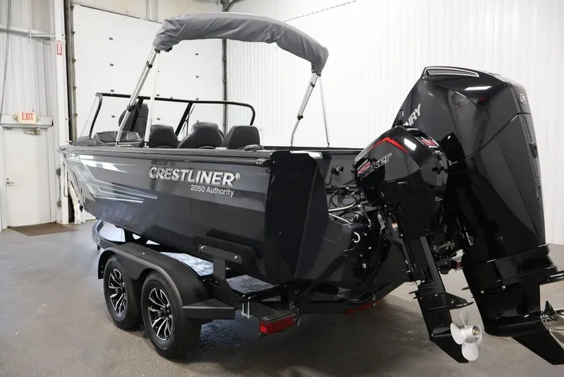 Slide: The Image of 2027 Crestliner 2050 Authority boat in showroom, featuring sleek design and powerful outboard motor. - 18