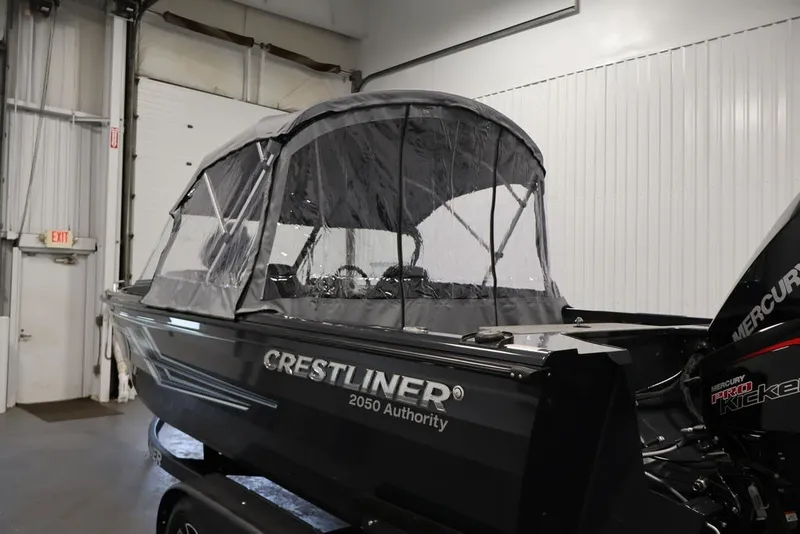 Slide: The Image of 2027 Crestliner 2050 Authority boat with canopy in a garage setting. - 62