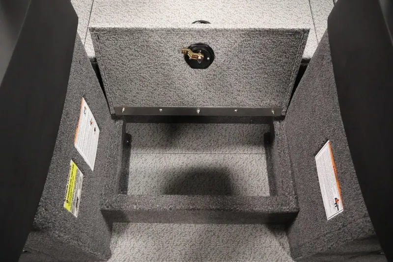 Slide: The Image of 2027 Crestliner 2050 Authority boat storage compartment with carpeted interior and safety labels. - 32