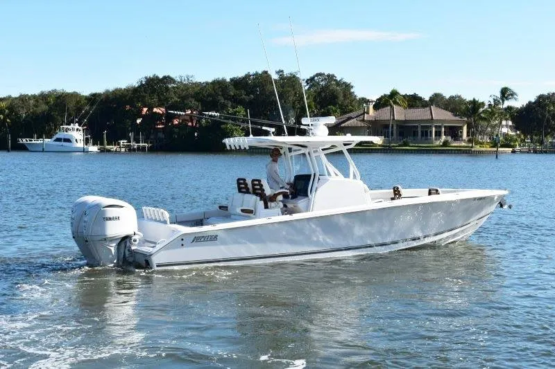 The Image of 2025 Jupiter 32 FS boat cruising on a calm lake with scenic background. - 0