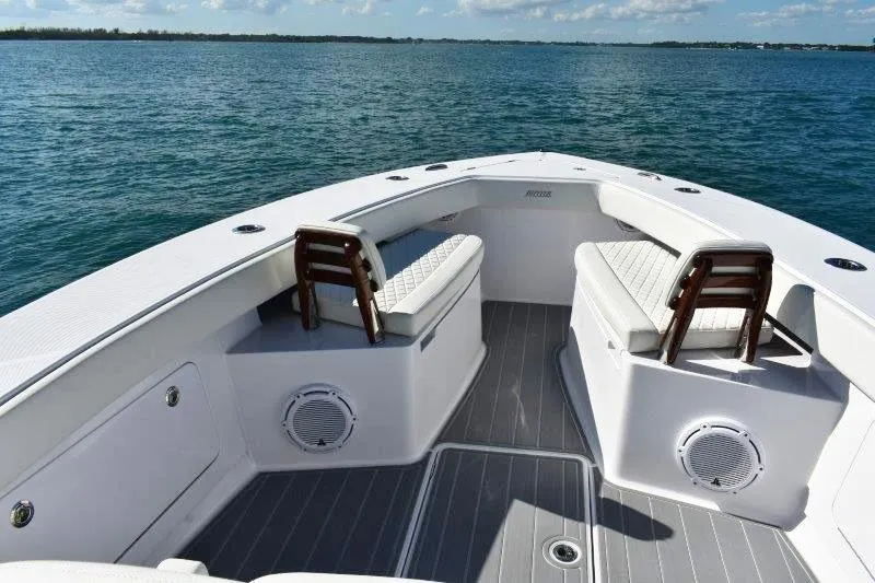 Slide: The Image of 2025 Jupiter 32 FS boat interior with cushioned seating on calm water. - 14
