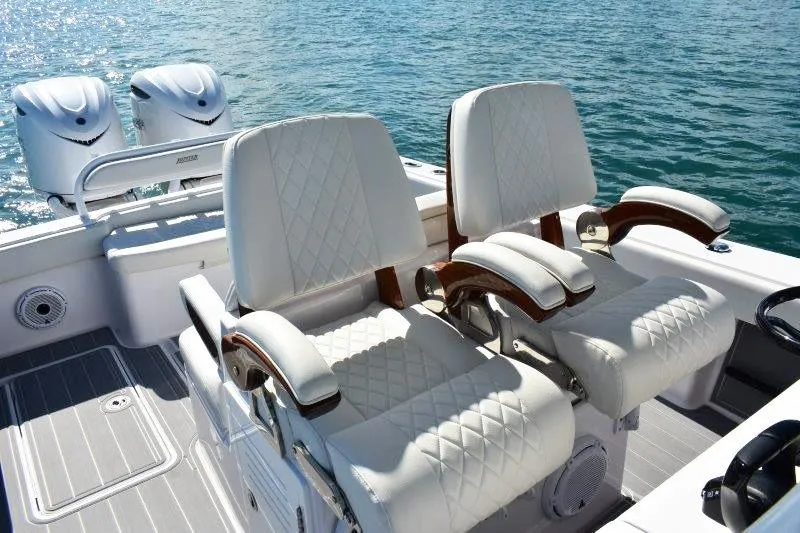 Slide: The Image of Luxury seating on 2025 Jupiter 32 FS boat with dual engines, on calm water. - 9