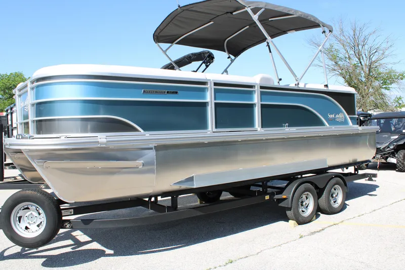 The Image of 2024 SunCatcher Select 22RC pontoon boat on trailer, featuring sleek blue design and canopy. - 0