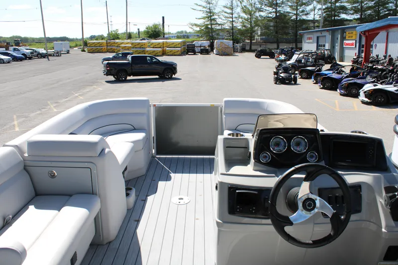 Slide: The Image of 2024 SunCatcher Select 22RC pontoon boat interior with steering console and seating in a parking lot. - 10