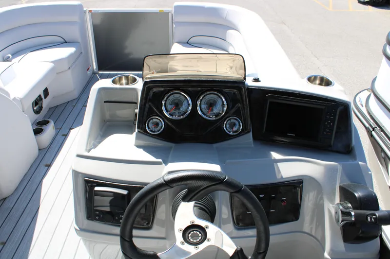 Slide: The Image of 2024 SunCatcher Select 22RC boat dashboard with steering wheel, gauges, and navigation screen. - 11