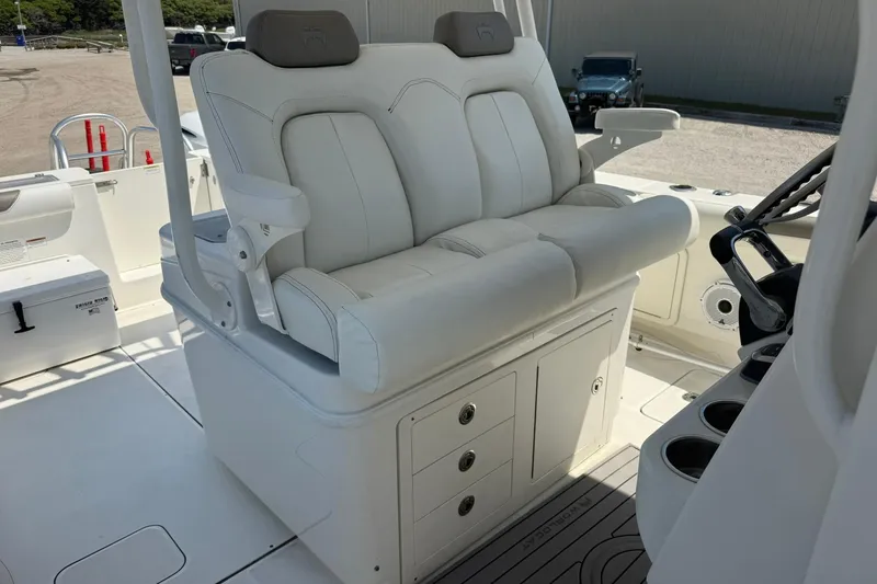Slide: The Image of 2020 World Cat 325 CC boat interior with white cushioned seating and storage compartments. - 14