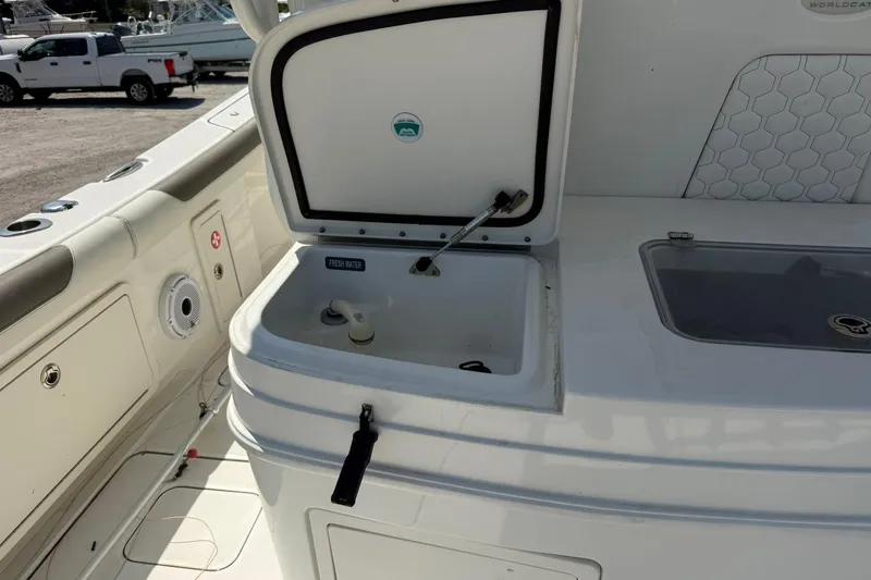 Slide: The Image of 2020 World Cat 325 CC boat interior with open storage compartment and fresh water access. - 16