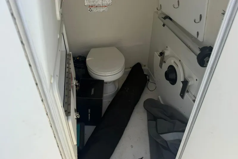 Slide: The Image of Interior of a 2020 World Cat 325 CC boat featuring a compact marine toilet. - 25