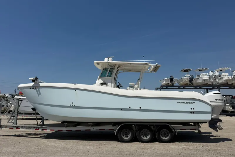 Slide: The Image of 2020 World Cat 325 CC boat on trailer under clear blue sky. - 7