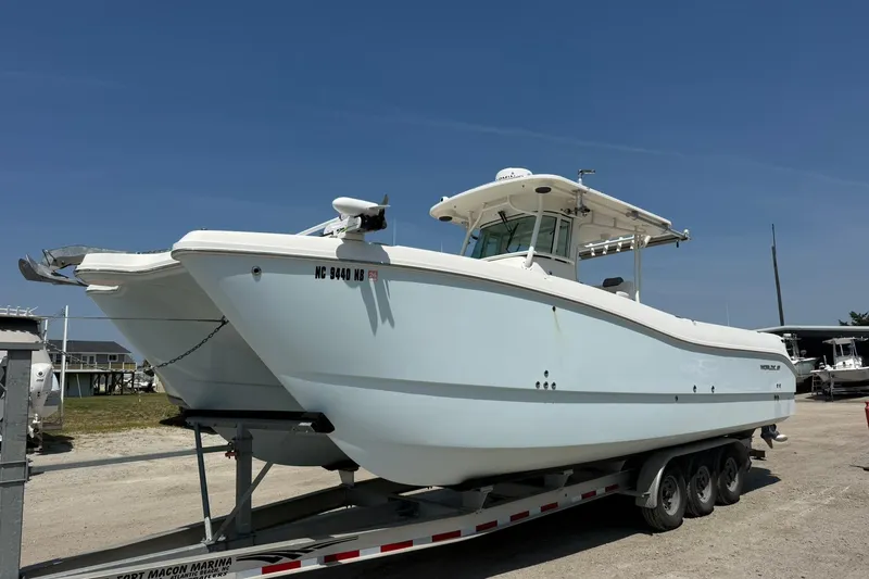 Slide: The Image of 2020 World Cat 325 CC boat on trailer at marina under clear blue sky. - 8