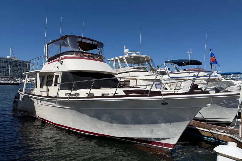Slide: The Image of 1988 Offshore Yachts 48 Sedan docked at marina under clear blue sky. - 1