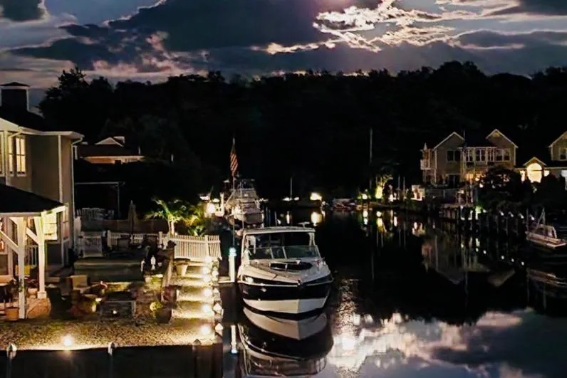 Slide: The Image of 2012 Cruisers Yachts 350 Express docked at night, illuminated waterfront scene. - 16