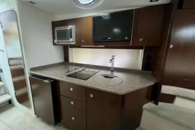 Slide: The Image of 2012 Cruisers Yachts 350 Express interior kitchen with modern appliances and sleek design. - 9