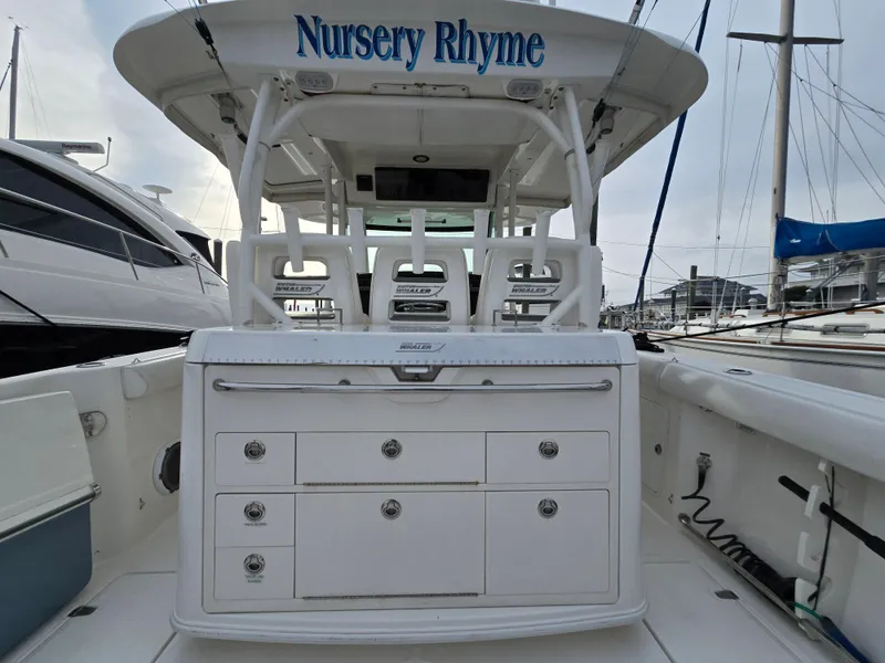 Slide: The Image of 2015 Boston Whaler 350 Outrage boat, named "Nursery Rhyme," docked at a marina. - 10