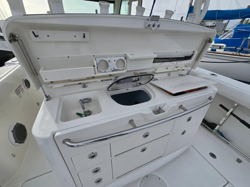 Slide: The Image of 2015 Boston Whaler 350 Outrage boat galley with sink, storage, and preparation area. - 11