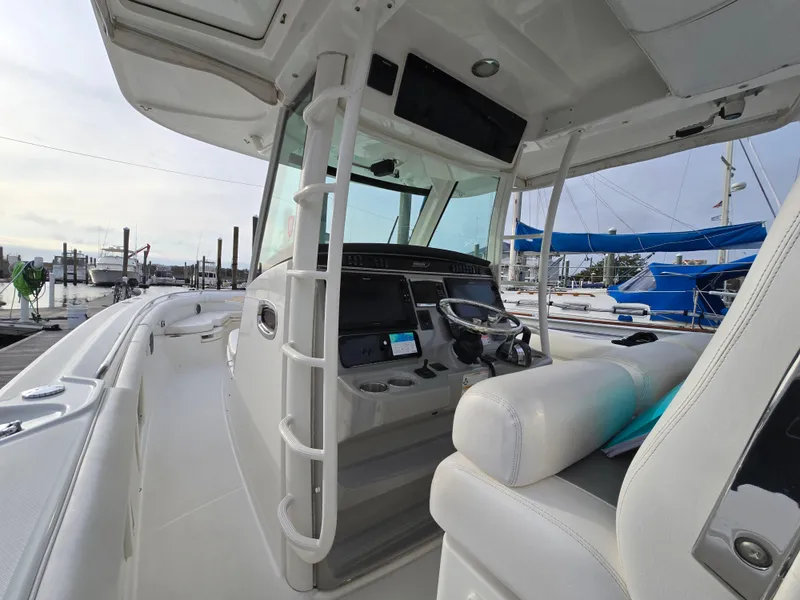 Slide: The Image of 2015 Boston Whaler 350 Outrage boat interior with helm and seating area. - 17