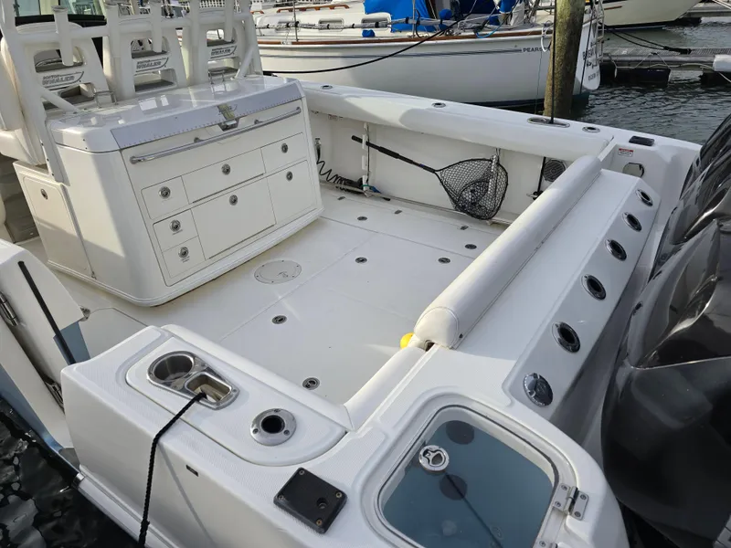 Slide: The Image of 2015 Boston Whaler 350 Outrage boat deck with seating and storage, docked at marina. - 23