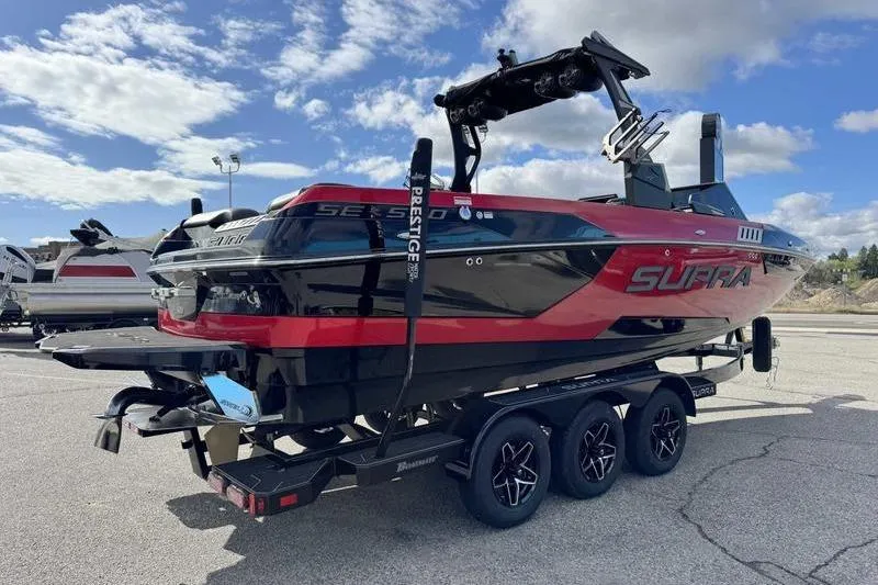 Slide: The Image of 2022 Supra SE boat in black and red on a trailer under a blue sky. - 5