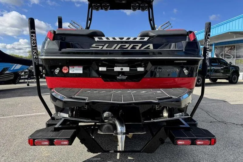 Slide: The Image of 2022 Supra SE boat rear view, showcasing sleek design and Prestige trailer. - 7