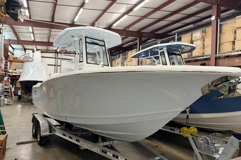 Slide: The Image of 2026 Tidewater 232 LXF boat in storage, on trailer, in a warehouse setting. - 2