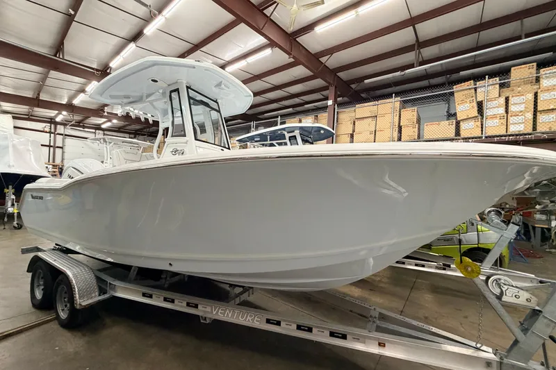 Slide: The Image of 2026 Tidewater 232 LXF boat on trailer in warehouse setting. - 3
