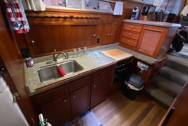 Slide: The Image of 1977 Uniflite 42 Convertible yacht kitchen with wooden cabinetry and granite countertops. - 11