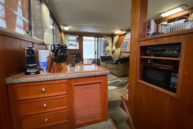 Slide: The Image of Interior of a 1977 Uniflite 42 Convertible yacht with cozy seating and kitchen area. - 13
