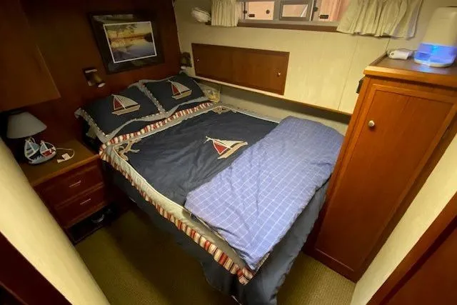 Slide: The Image of Cozy bedroom in 1977 Uniflite 42 Convertible yacht with nautical-themed bedding. - 14