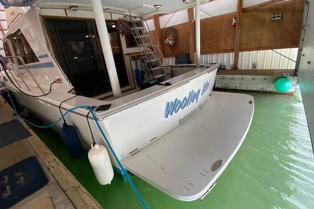 Slide: The Image of 1977 Uniflite 42 Convertible yacht docked in a marina with green water. - 17