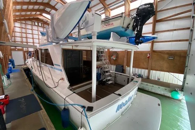 Slide: The Image of 1977 Uniflite 42 Convertible boat docked in a covered marina. - 18