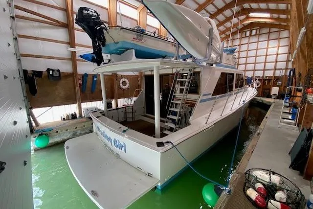 Slide: The Image of 1977 Uniflite 42 Convertible boat docked indoors with a small motorboat on top. - 19