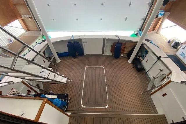 Slide: The Image of 1977 Uniflite 42 Convertible boat deck with wooden flooring and storage compartments. - 2