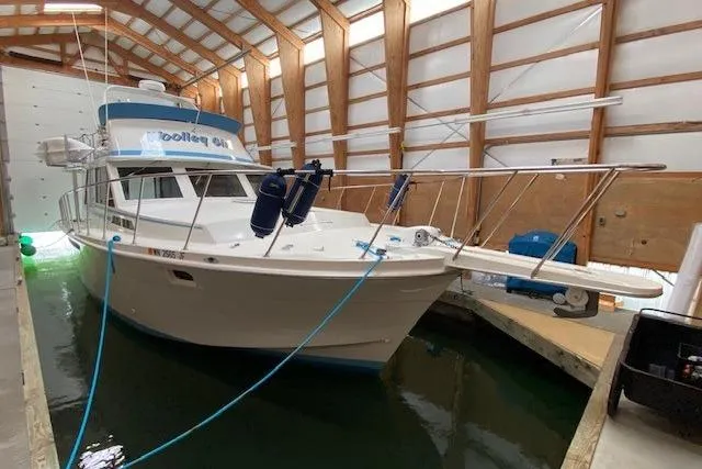 Slide: The Image of 1977 Uniflite 42 Convertible boat docked in a covered marina. - 21