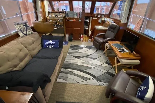 Slide: The Image of Interior of a 1977 Uniflite 42 Convertible yacht with cozy seating and nautical decor. - 5