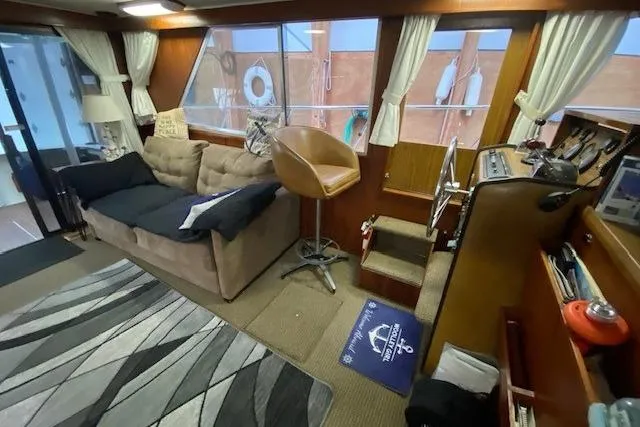 Slide: The Image of 1977 Uniflite 42 Convertible yacht interior with sofa, chair, and nautical decor. - 7