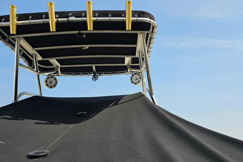 Slide: The Image of 2003 Caravelle 230 Walk Around Stern Drive boat with canopy and speakers against blue sky. - 13