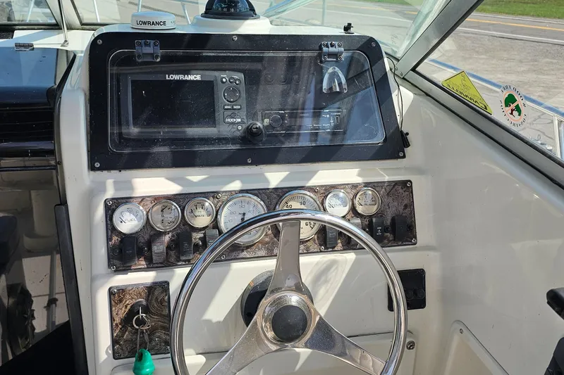Slide: The Image of Dashboard of a 2003 Caravelle 230 Walk Around Stern Drive boat with steering wheel and gauges. - 16