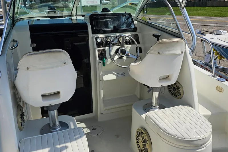 Slide: The Image of Interior of a 2003 Caravelle 230 Walk Around Stern Drive boat with steering wheel and seats. - 19