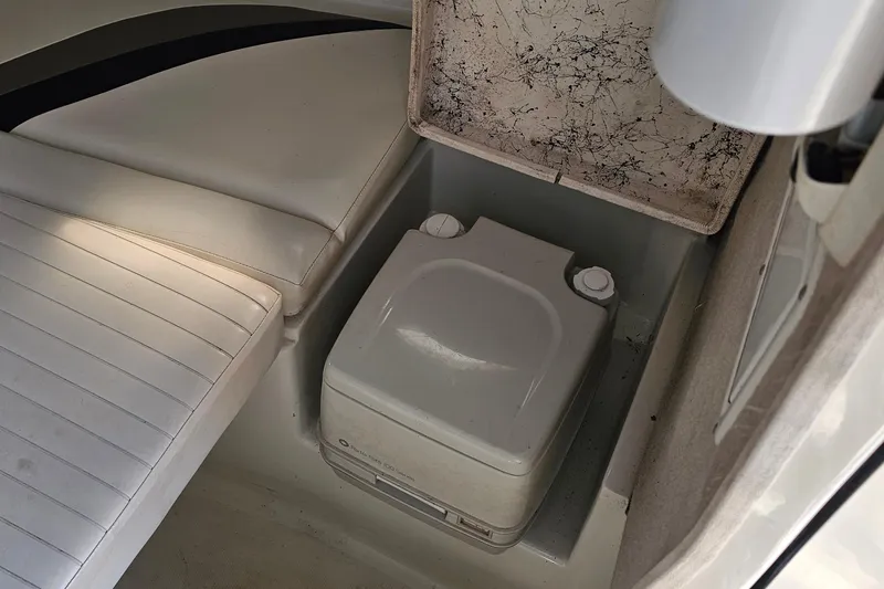 Slide: The Image of 2003 Caravelle 230 Walk Around Stern Drive boat interior with portable toilet. - 23