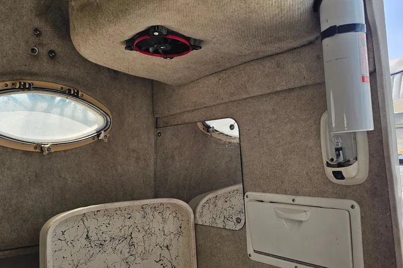 Slide: The Image of Interior of 2003 Caravelle 230 Walk Around Stern Drive boat cabin with window and fire extinguisher. - 25