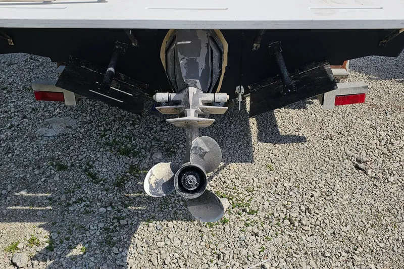 Slide: The Image of Rear view of a 2003 Caravelle 230 Walk Around Stern Drive boat on gravel. - 9