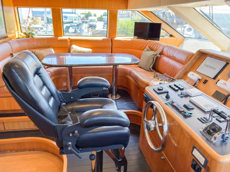 Slide: The Image of Interior of a 2004 Cheoy Lee 68 Motor Yacht, featuring helm and leather seating. - 16