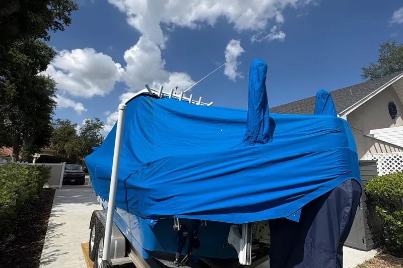 Slide: The Image of Covered 2019 Blue Wave 2800 Pure Hybrid boat on trailer under blue sky. - 28