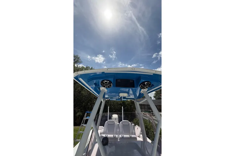 Slide: The Image of 2019 Blue Wave 2800 Pure Hybrid boat under sunny sky, showcasing T-top and seating. - 36