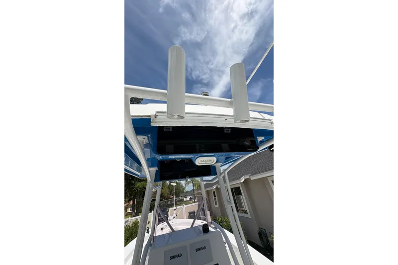 Slide: The Image of 2019 Blue Wave 2800 Pure Hybrid boat with T-top and electronics, under a clear sky. - 39