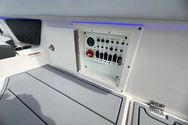 Slide: The Image of Control panel on 2026 Chaparral 6 SSX boat, featuring switches and a red dial. - 19