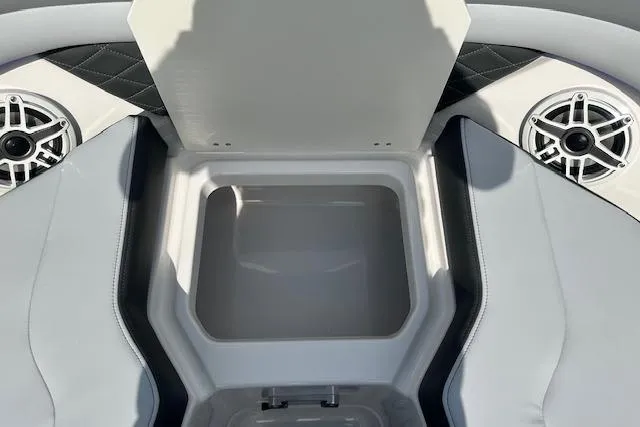 Slide: The Image of 2026 Chaparral 6 SSX boat interior storage compartment with speakers and cushioned seating. - 48