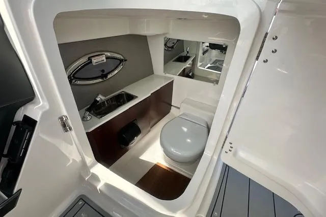 Slide: The Image of 2026 Chaparral 6 SSX boat interior bathroom with sink, toilet, and mirror. - 62